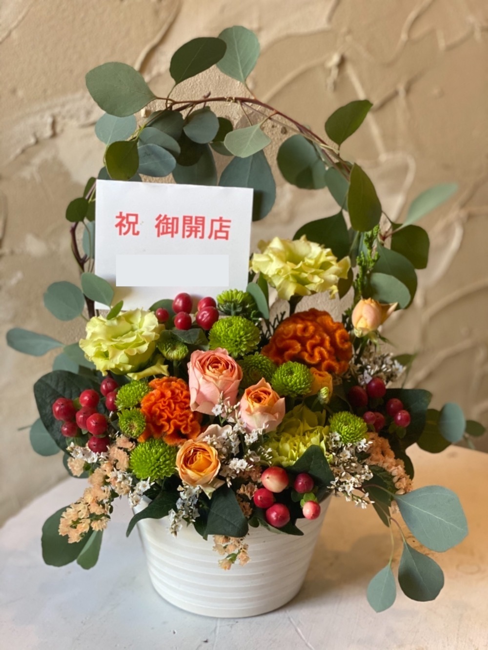 「いつでも明るい気持ちで笑顔溢れるお店で いて下さい」華やかな開店祝い花